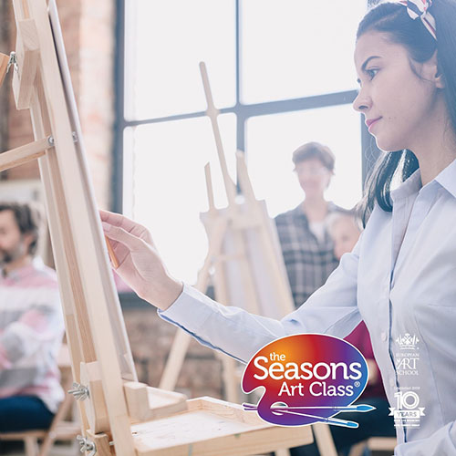 student focused on painting in art class with multiple easels and classmates enjoying creative learning during five seasonal sessions